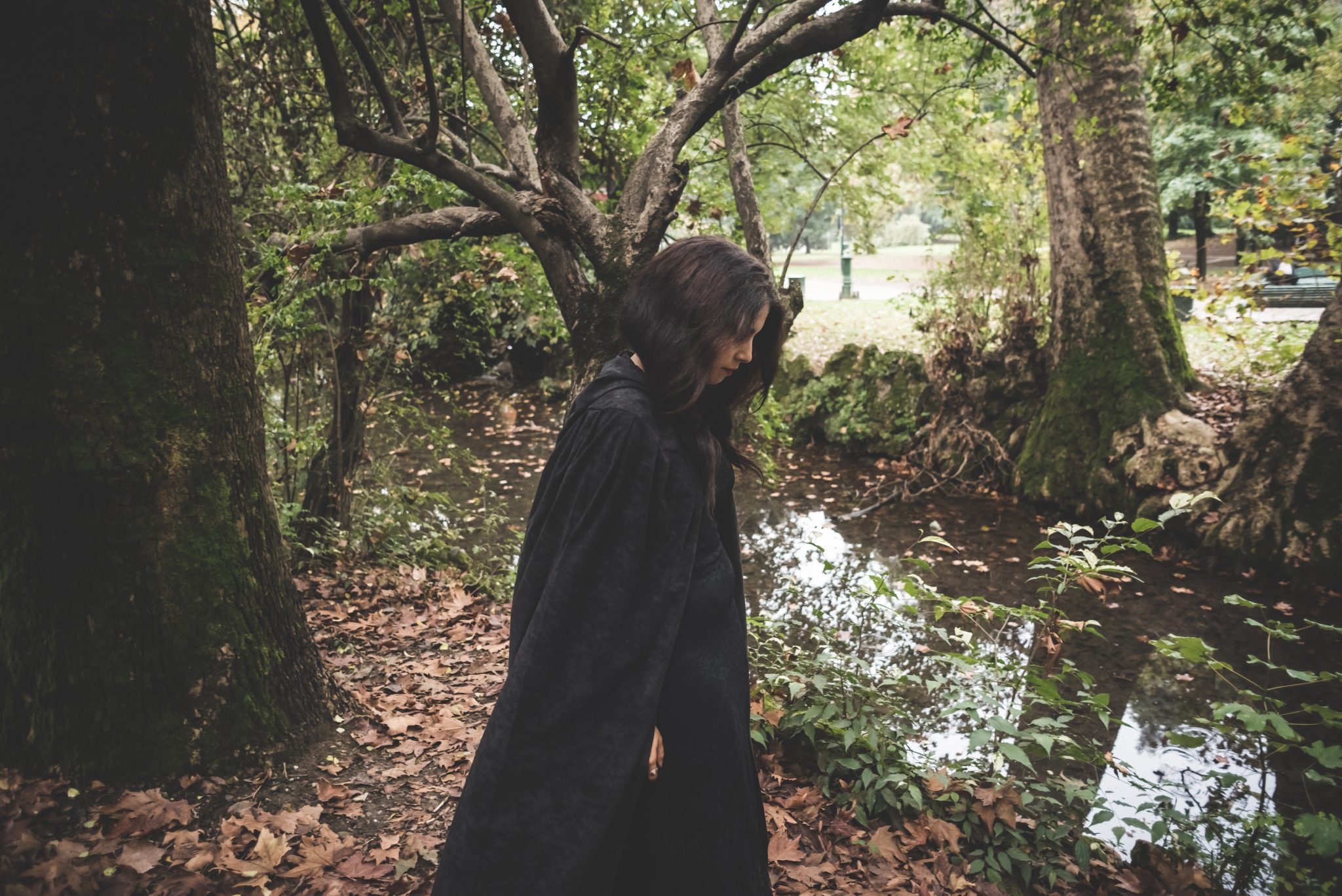 Beautiful dark vampire woman with black mantle and hood